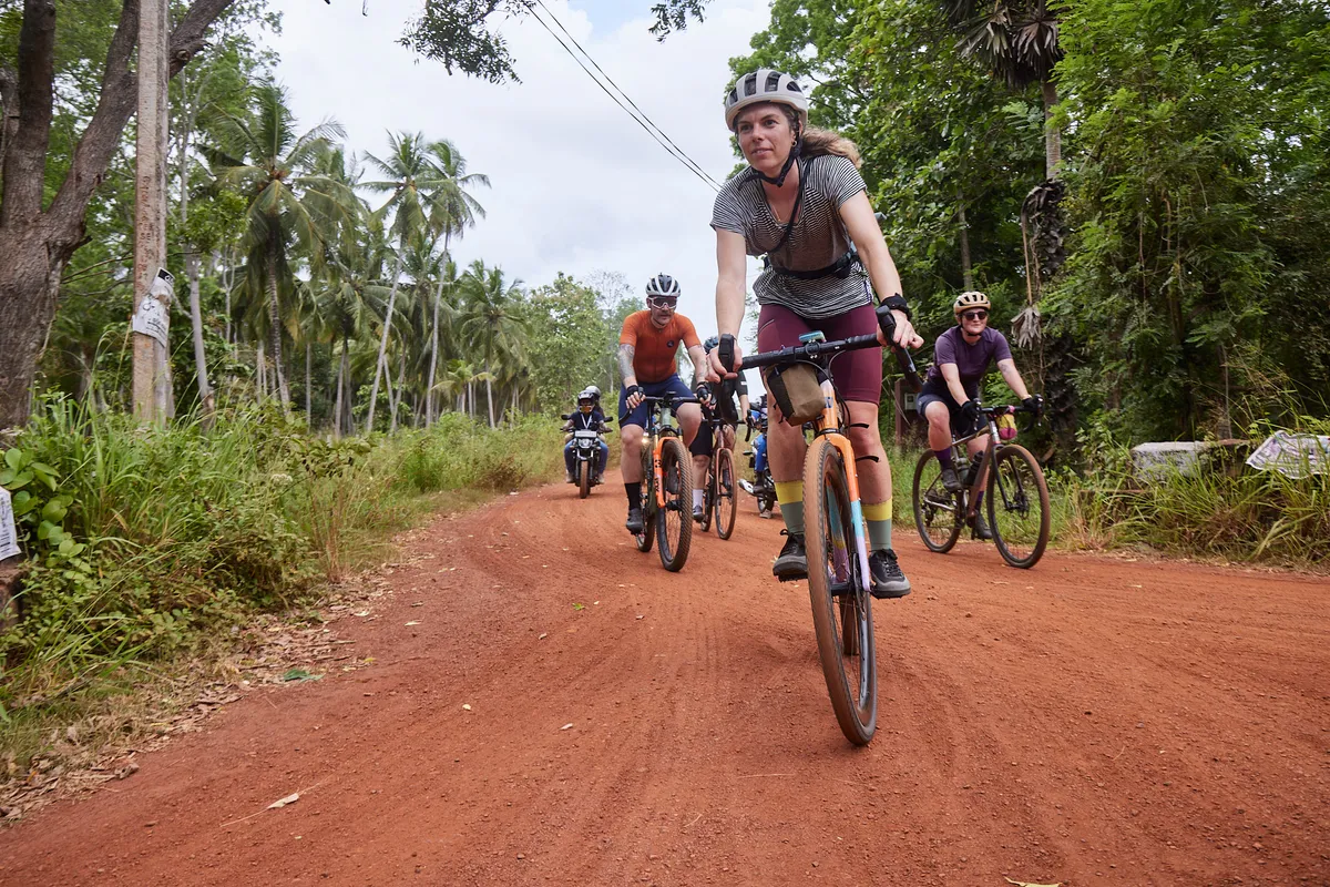Group cycling in Sri Lanka through forest.
