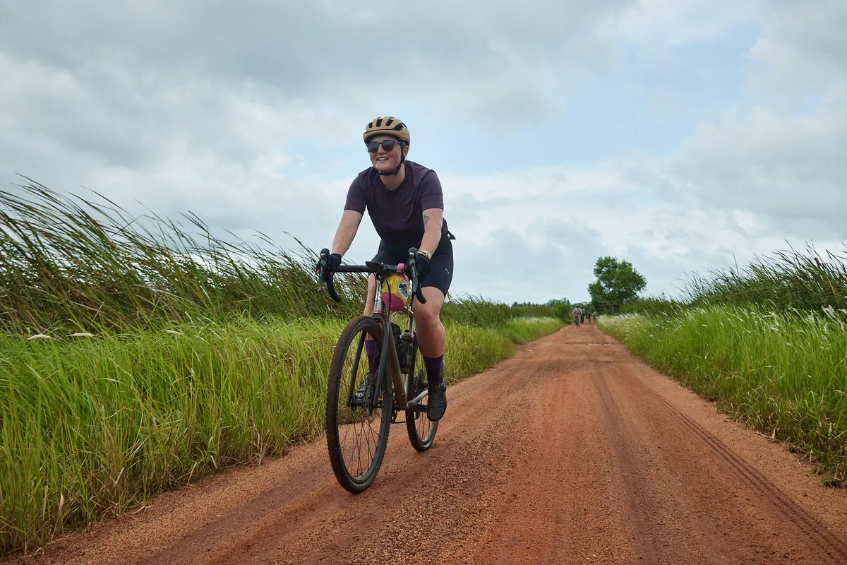 Katherine Moore cycling in Sri Lanka along red road.