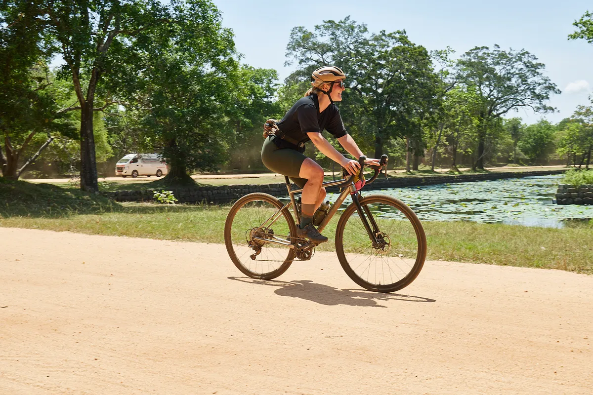 Katherine Moore riding gravel bike along trail in Sri Lanka.