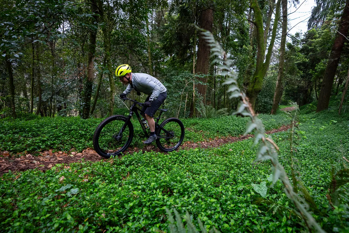 Male rider in grey top riding the Cannondale Scalpel 1 full suspension mountain bike