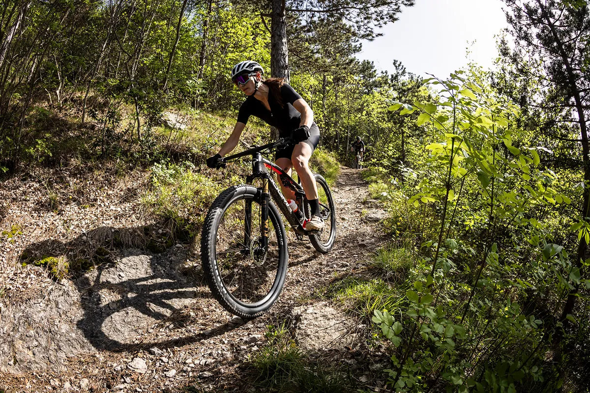 Female rider in black riding the Pinarello Dogma XC full suspension mountain bike