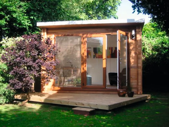 A rectangular wooden shed offers a light and airy office space in the garden.