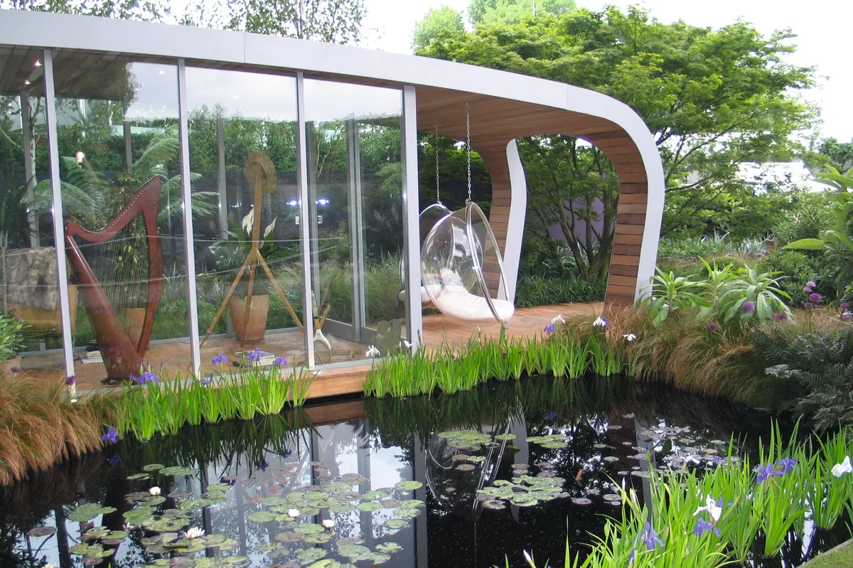 An outdoor glass structure offers a modern alternative design to a garden office
