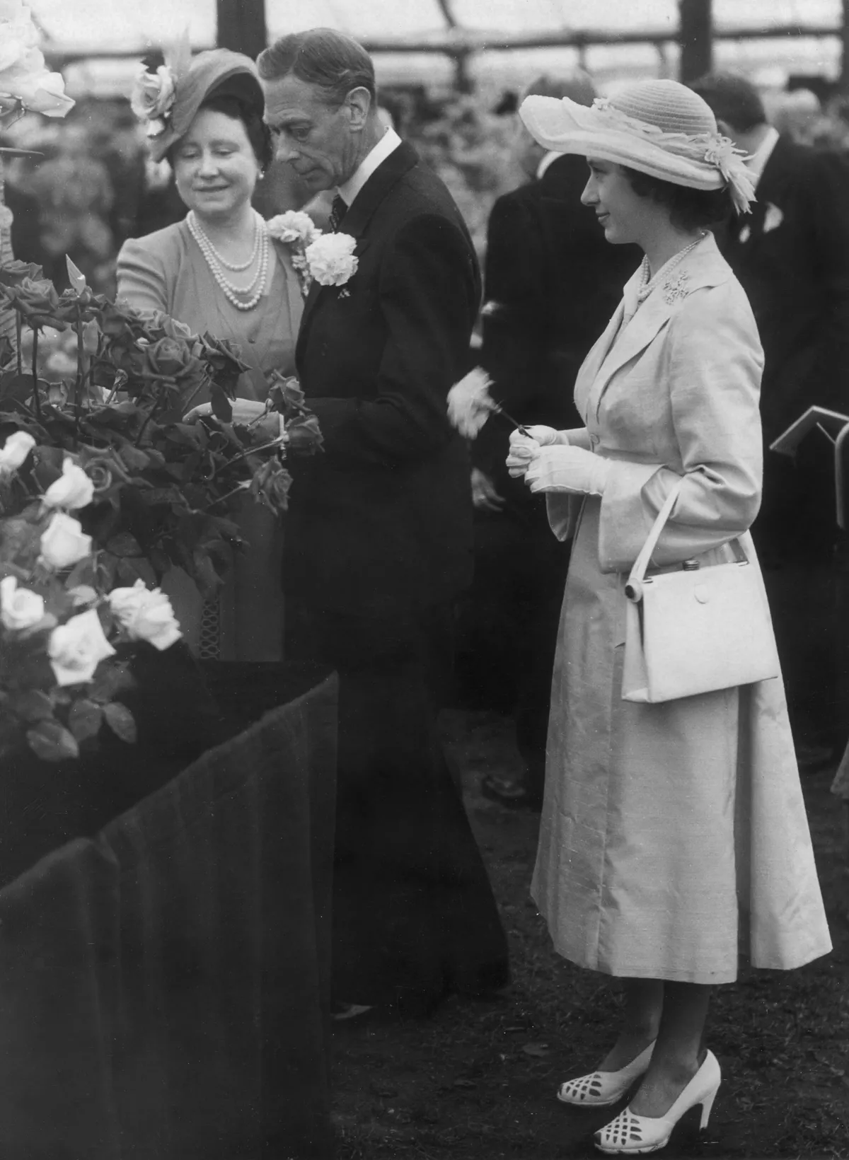 The QMay 1951: The Queen and King George VI admiring Harry Mallory type roses at the Chelsea Flower Show in the grounds of the Royal Hospital. Princess Margaret stands behind them. ueen and King George VI at the Chelsea Flower Show in 1951