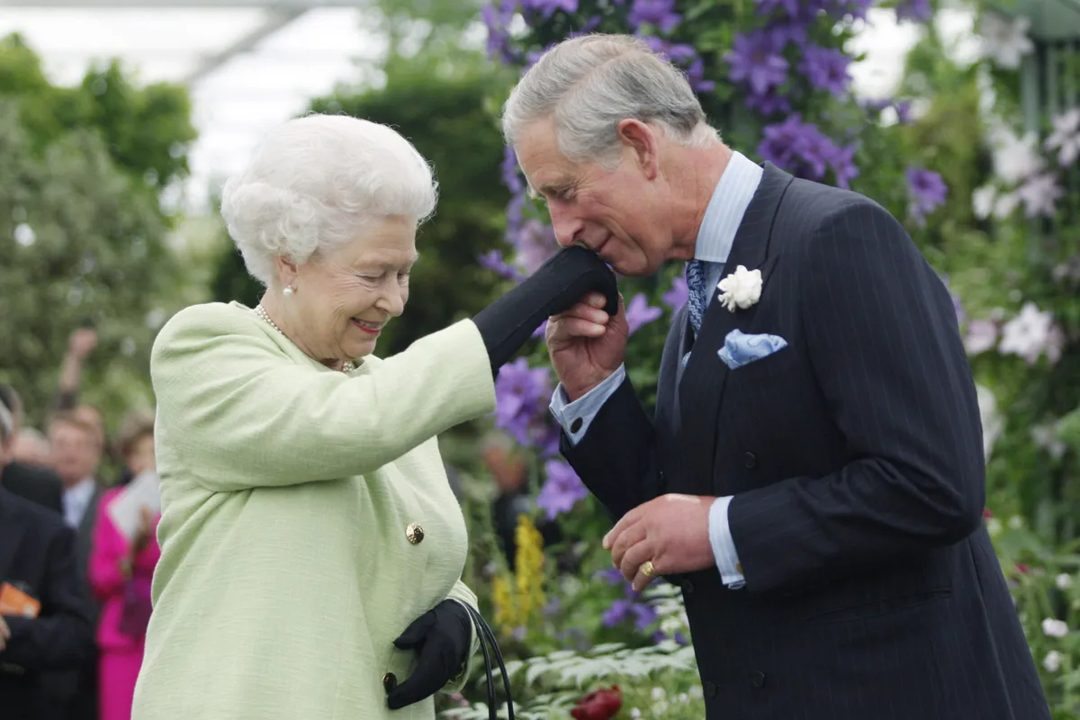 2009: Queen Elizabeth II presents Prince Charles, Prince of Wales with the Royal Horticultural Society's Victoria Medal of Honour during a visit to the Chelsea Flower Show in 2009 in London.