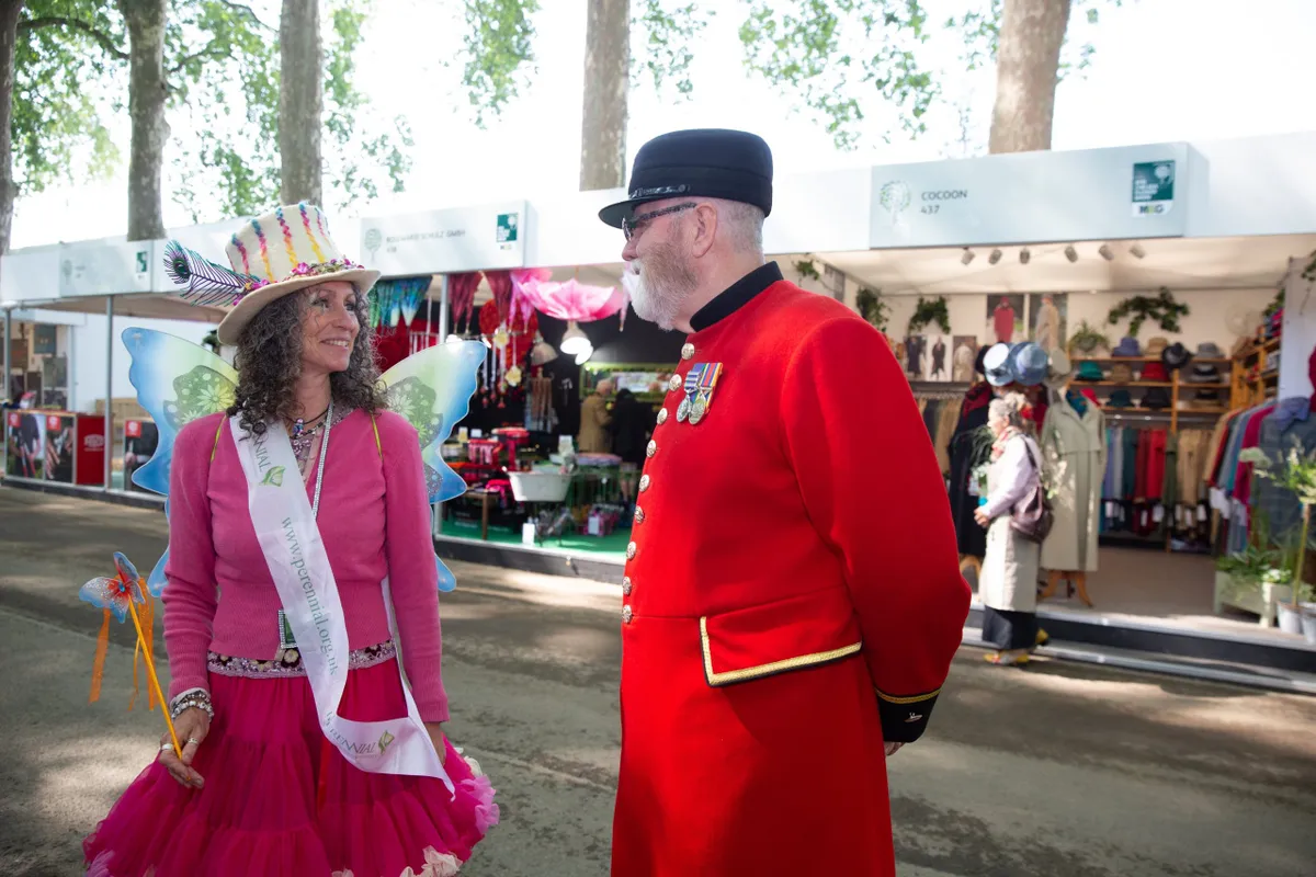A Chelsea Pensioner chats with Janis Goodall, who was dressed as a fairy at the Perennial Gardeners Royal Benevolent Society tradestand during press day at the the RHS Chelsea Flower Show 2018 in London, May 21, 2018. RHS/Suzanne Plunkett