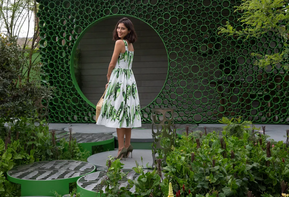 Chef Jasmine Hemsley, wears Dolce & Gabbana's new Snap Pea dress as she poses in The Seedlip Garden, which features 40 different varieties of pea plants during press day at the the RHS Chelsea Flower Show 2018 in London, May 21, 2018. RHS/Suzanne Plunkett