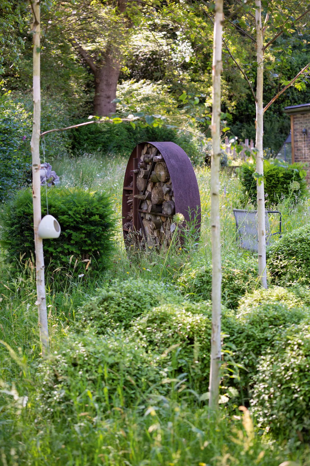 A focal point for the garden is the bespoke Corten steel log-store. “We’ve worked with a wonderful steel fabricator for the past 12 years,” says Amanda. Designed as a bug hotel, the logs remain in situ. “We’ve found leaf-cutter bees laying eggs in the bamboo canes, which is lovely.”