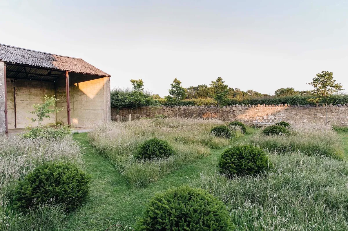 The open-sided Store – an old tractor shed – looks out over the Willow Garden with its topiary yew domes and tantalising grid of long grass. On the other side of the Store is the more relaxed open space known as The Meadows.