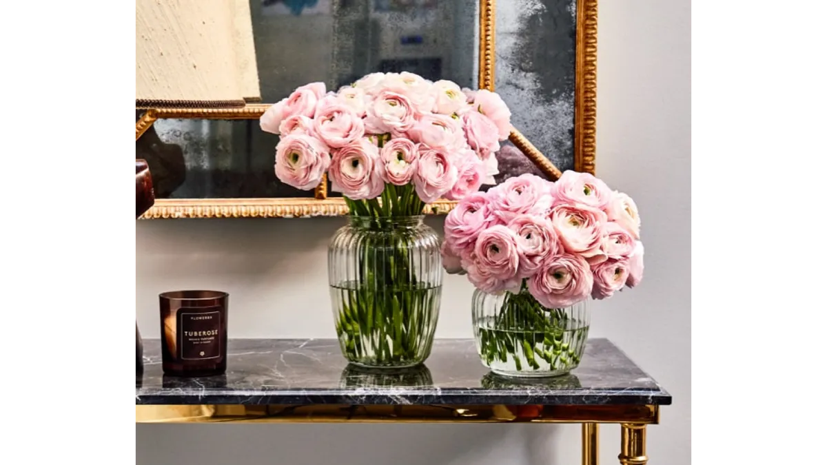 Two vases of roses on a hall table.
