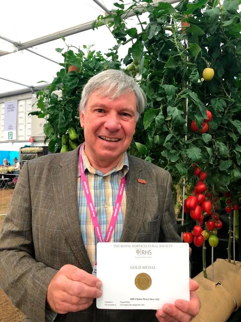 Burpee's Simon Crawford proudly show's off their stand's Gold Medal award for their Ten Tomatoes That Changed the World display.