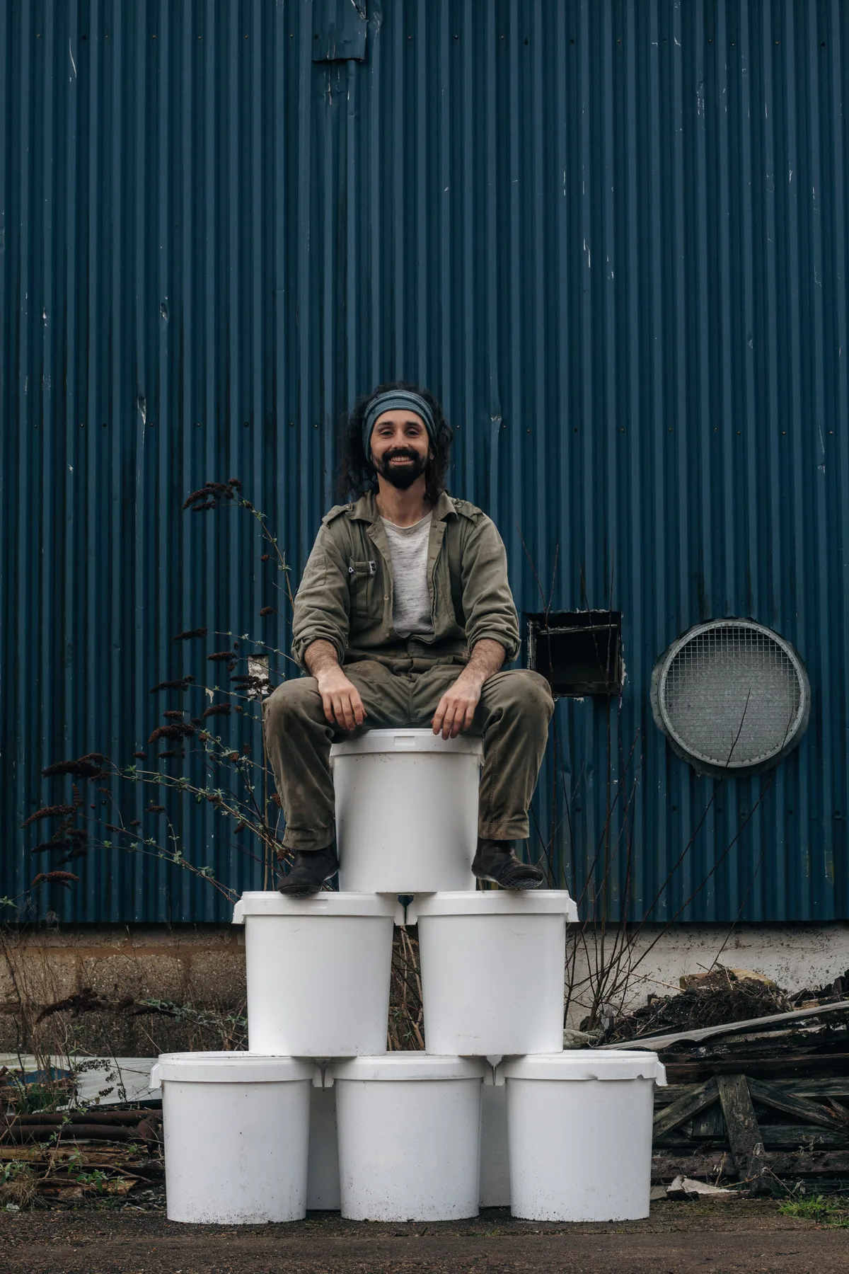 Michael Kennard sitting on buckets of his organic compost