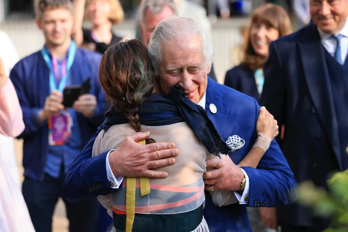 After requesting a hug Korean designer Jihae Hwang and King Charles III share an embrace on her A Letter From A Million Years Past Garden at RHS Chelsea Flower Show 2023.