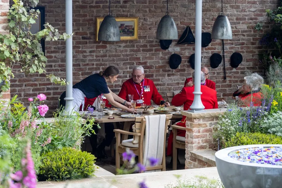 Chelsea pensioners eating at meal in the Savills Garden. Designed by Mark Gregory.