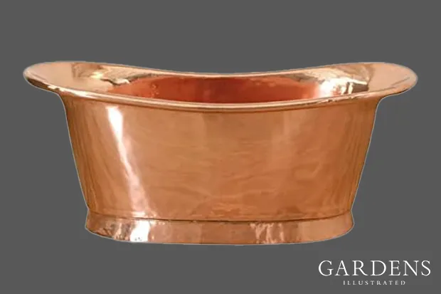 A copper bath tub on a grey background