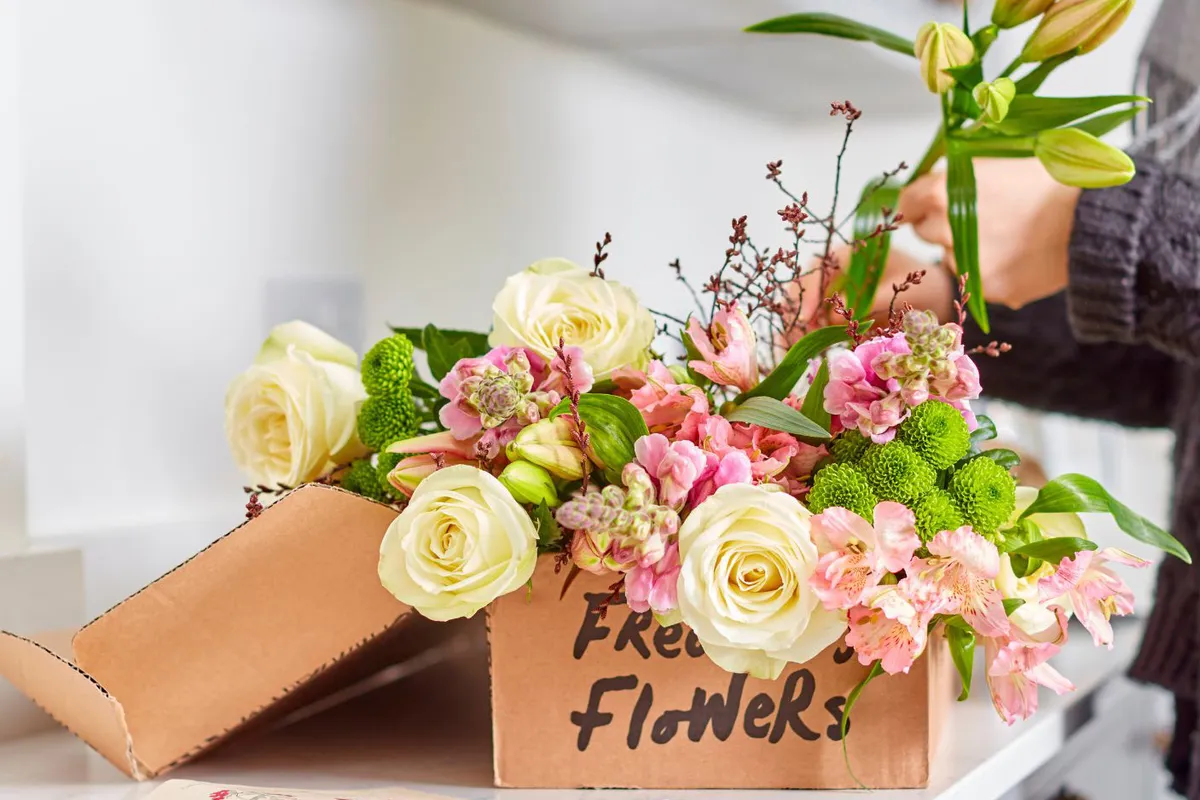 Person unboxing Freddie's Flowers deliveries