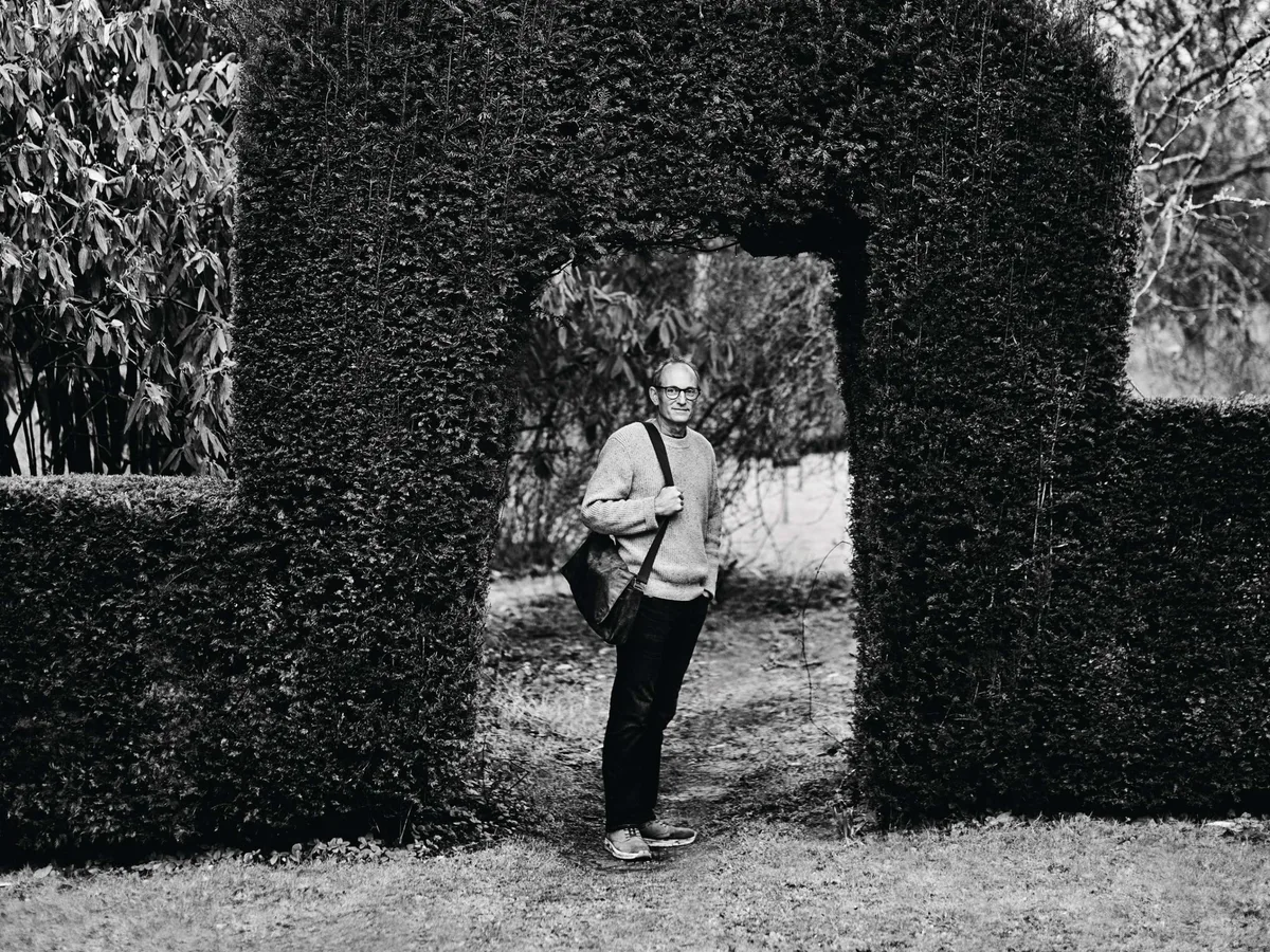 Tom Hoblyn Black and white image of man stood under a hedge arch