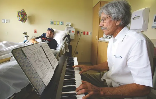 A music practitioner plays for a stroke patient at Florida Hospital Oceanside (© Press Association)