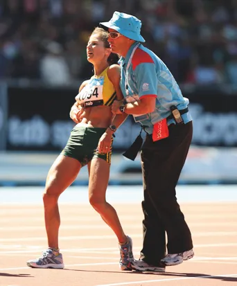 Kate Smyth was escorted from the track when she collapsed after running the marathon at the 2006 Commonwealth Games © Getty Images