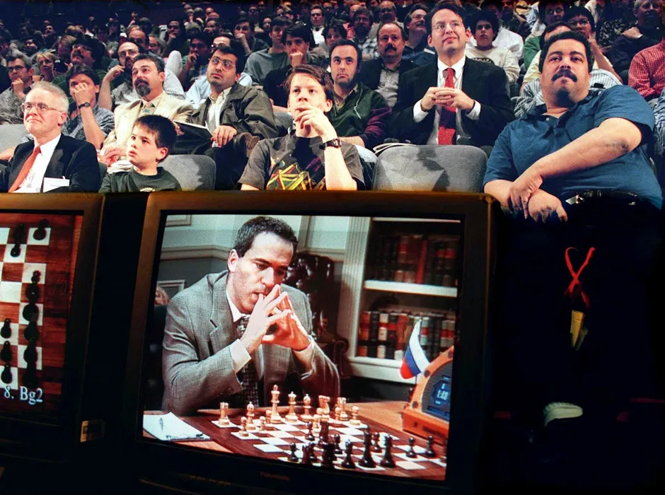 Fans watch the fifth game between World Chess Champion Garry Kasparov (on TV monitor) and the IBM Deep Blue computer 10 May in New York © Stan Honda/AFP/Getty Images)