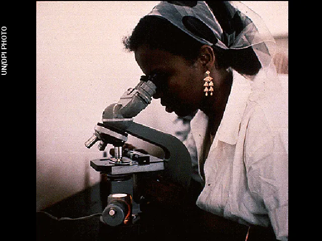 Woman with microscope © UN/DPI Photo