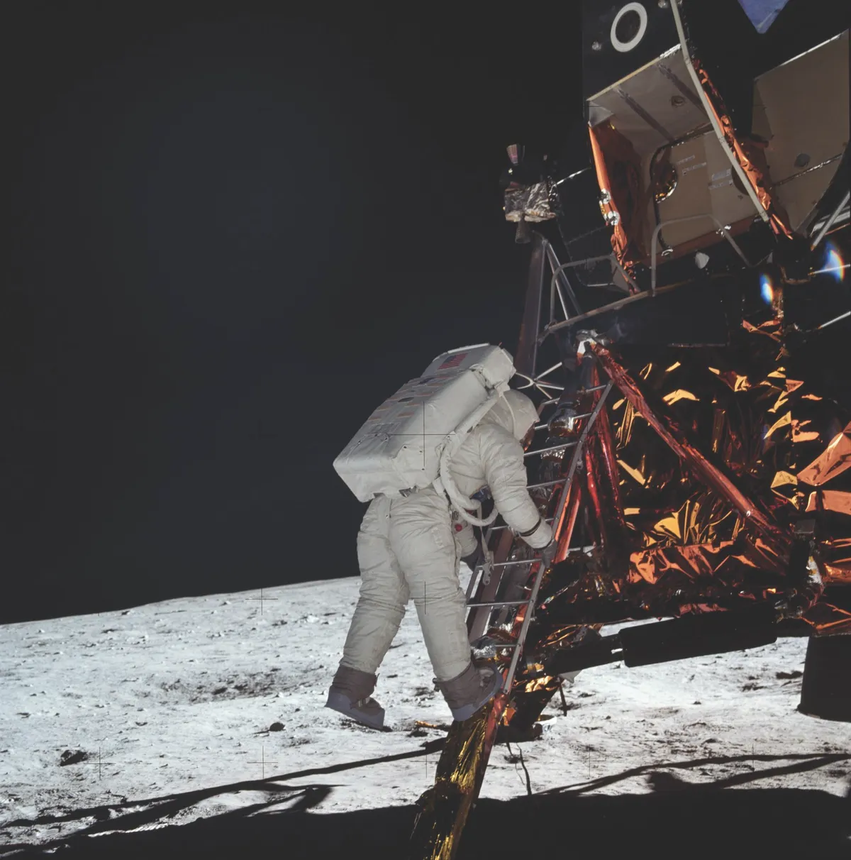 Half an hour after stepping out of the lunar module, Armstrong captures shots of his crew-mate Aldrin making the same feet-first exit onto the Moon. It takes Aldrin three minutes to make it to the bottom of the lunar module’s ladder. © NASA/JPL