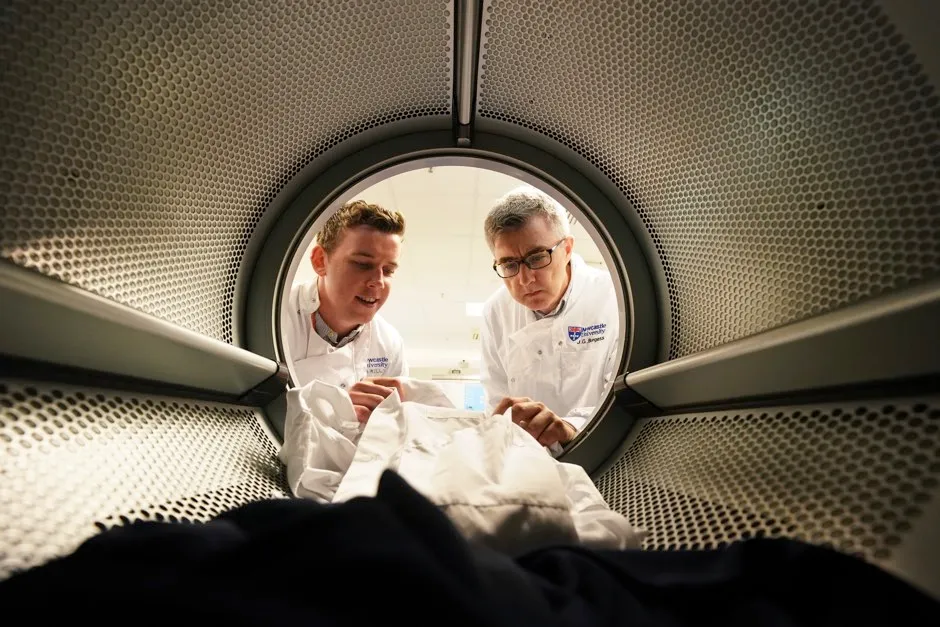 Max Kelly (left) and marine microbiologist Professor J Grant Burgess check clothing in a washing machine © Owen Humphreys/PA
