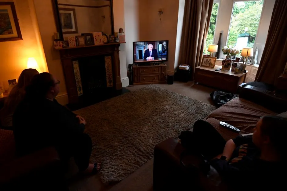 A family in Bradford watch Britain's Prime Minister Boris Johnson give a televised message to the nation to announce a new alert system and a possible timeline for the gradual lifting of the lockdown on May 10, 2020 in Bradford, England. The UK is continuing with quarantine measures intended to curb the spread of Covid-19, but as the infection rate is falling government officials have been discussing the terms under which it would ease the lockdown. (Photo by George Wood/Getty Images)