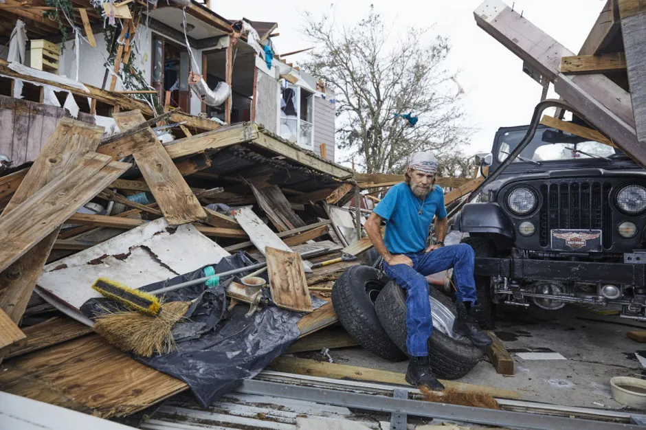 A man sits outside a hurricane-destroyed house in Lake Charles, Louisiana, USA