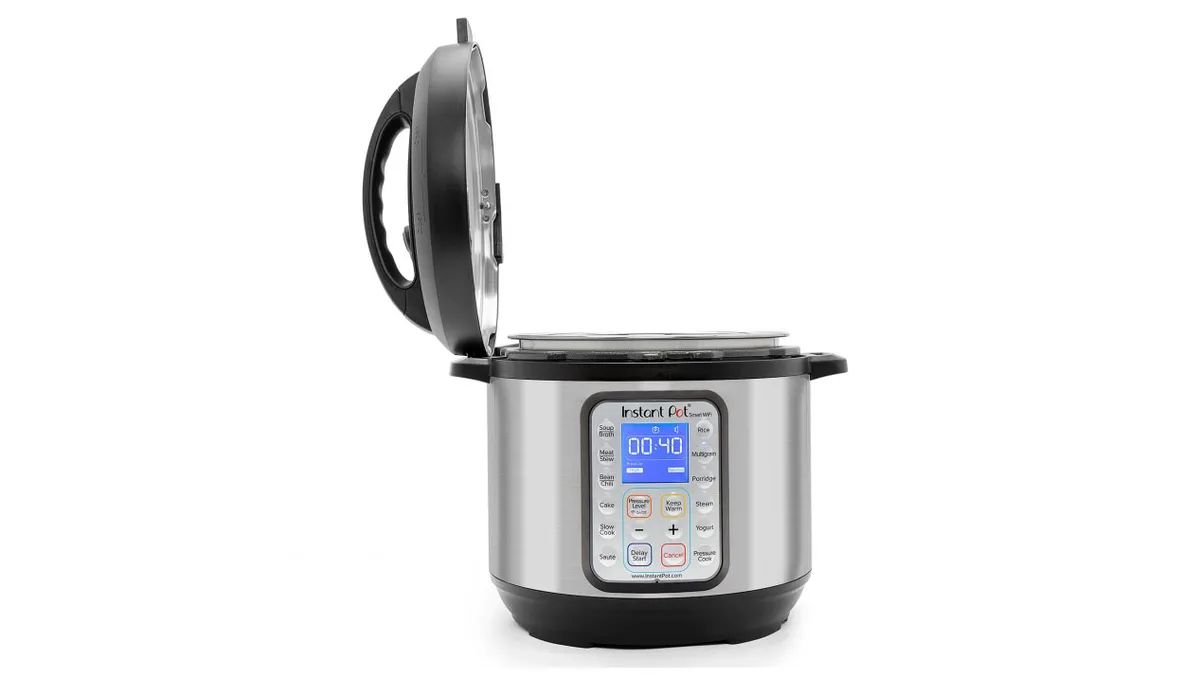 An instant cooking pot with open lid on a white background.