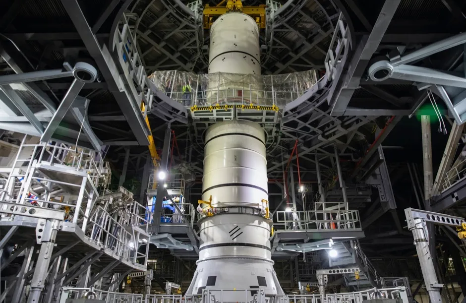 Technicians with NASA’s Exploration Ground Systems lower a mock-up, or pathfinder, of the Space Launch System’s (SLS) center booster segment onto an aft pathfinder segment inside the Vehicle Assembly Building (VAB) at the agency’s Kennedy Space Center © NASA