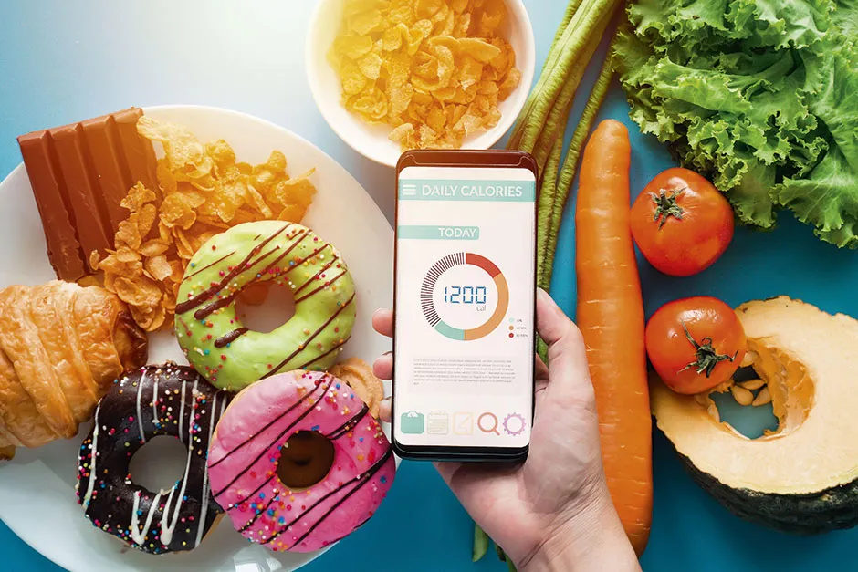 A calorie counting app in front of plates of food © Alamy