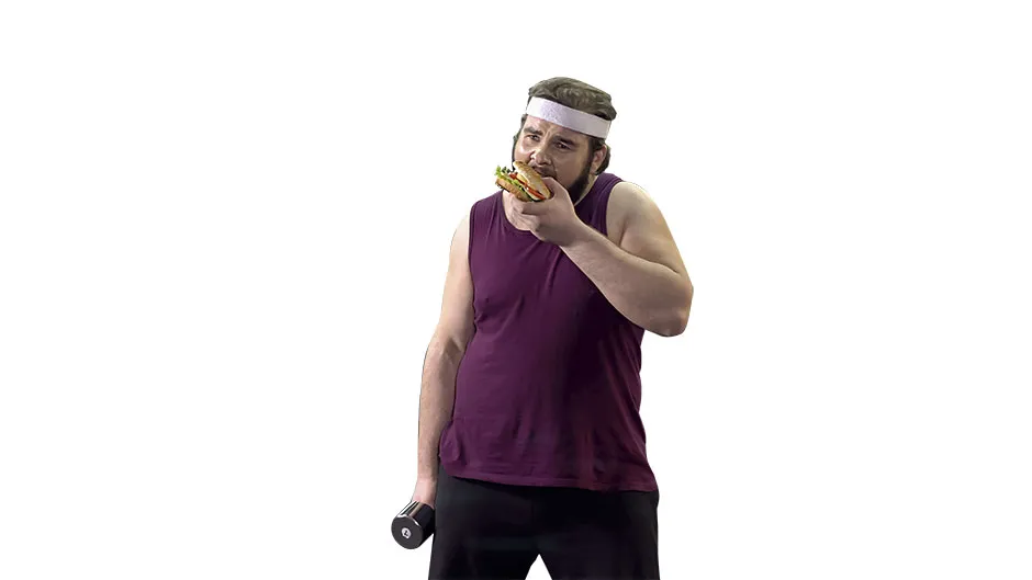A man in workout clothes eating a burger © Getty Images