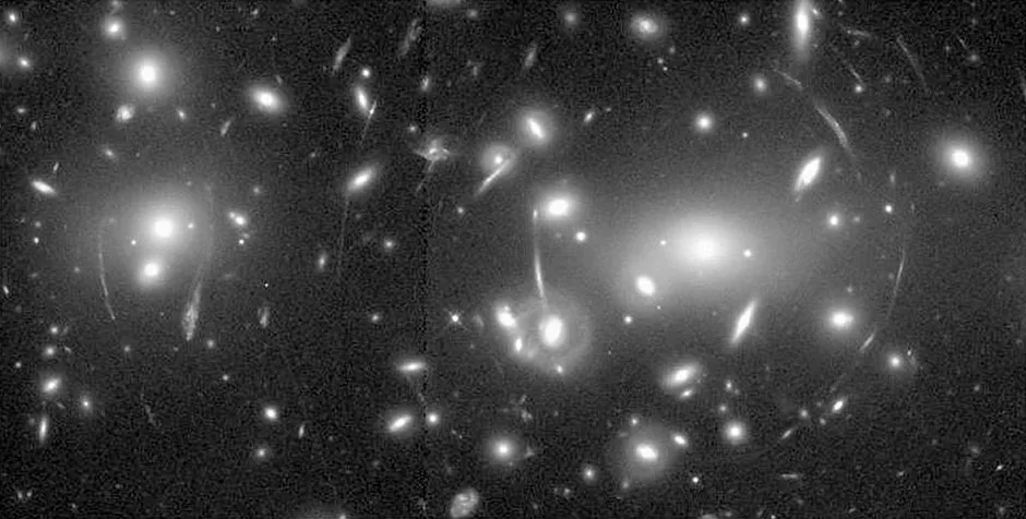 The galaxy cluster Abell 2218 showing gravitational lensing, captured by the Hubble Space Telescope © Getty Images