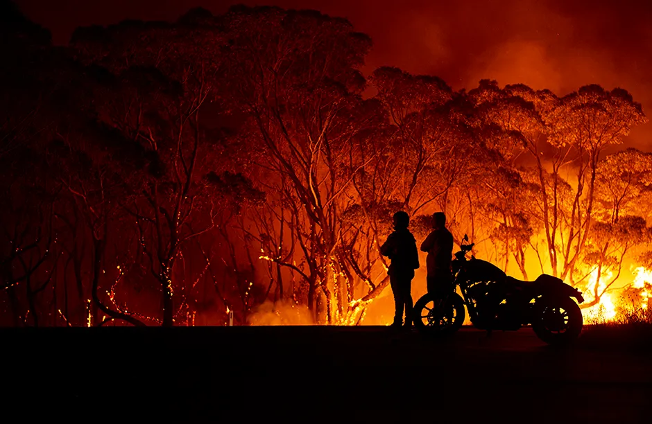 LAKE TABOURIE, AUSTRALIA - JANUARY 04: Residents look on as flames burn through bush on January 04, 2020 in Lake Tabourie, Australia. A state of emergency has been declared across NSW with dangerous fire conditions forecast for Saturday, as more than 140 bushfires continue to burn. There have been eight confirmed deaths in NSW since Monday 30 December. 1365 homes have been lost, while 3.6 million hectares have been burnt this fire season