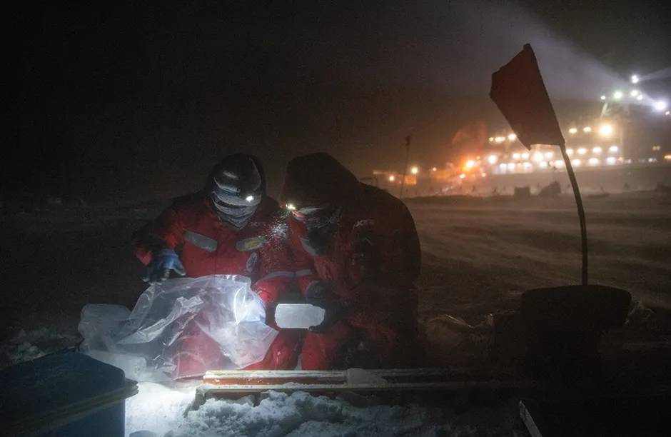 Lei Wang (r) and Michael Angelopolous (l) collect ice cores, which cores will be melted and measured in the lab of Polarstern.