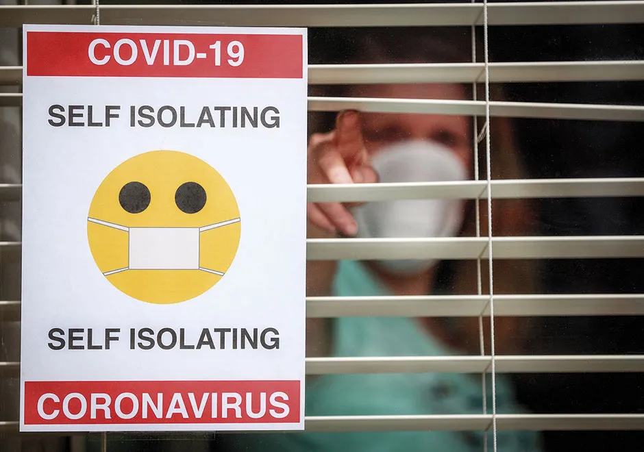 A sign saying 'COVID-19: Self Isolating' © Alamy