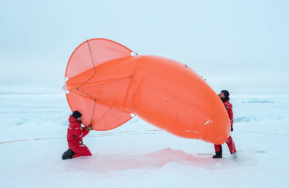 Atmospheric scientists Alex Schulz and Sandro Dahlke deflate Miss Piggy, a weather balloon used to deploy instruments that help the scientists understand atmospheric properties like temperature and turbulance.