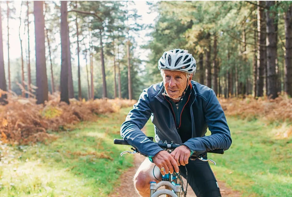 Senior man on a bicycle in the forest