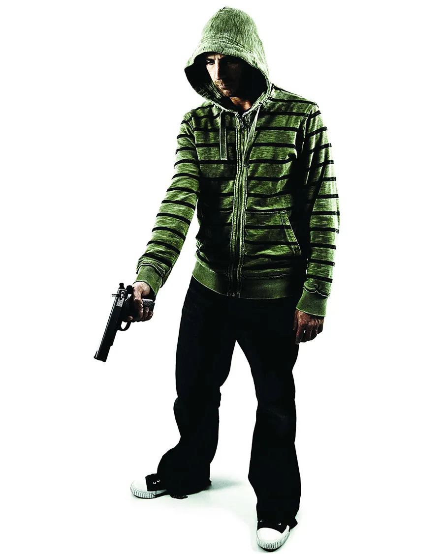 man wearing green hoodie holding a gun