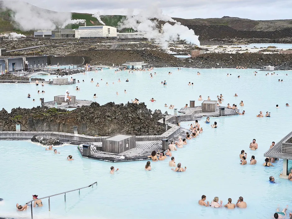 A large group of people relaxing in a pale blue lagoon © Luca Locatelli/Institute