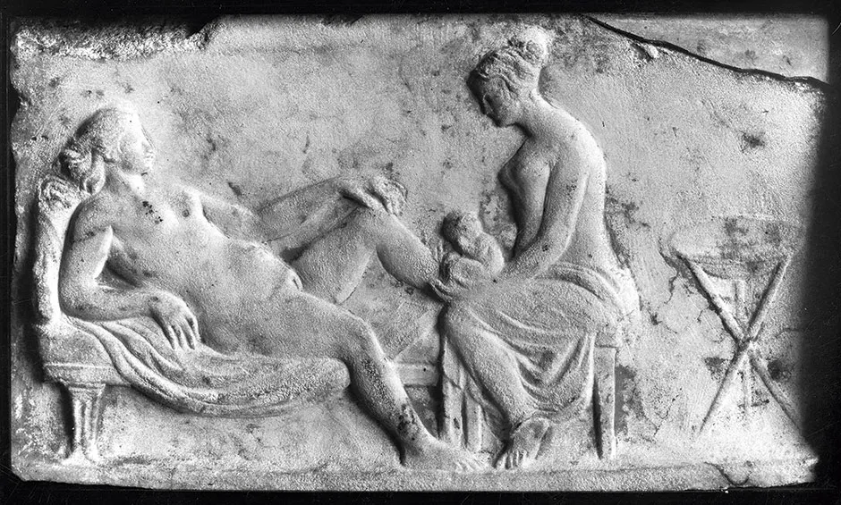 Carving from Ancient Rome of a midwife helping a woman give birth © Wellcome Trust Image Library