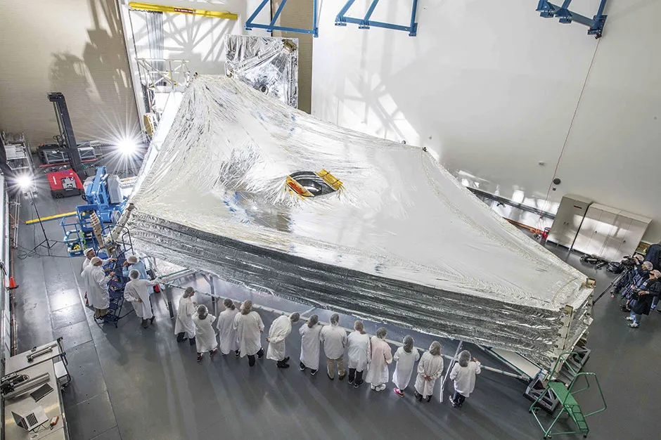 The JWST’s sunshield is the largest part of the observatory. The five layers of thin membrane must unfold precisely to provide a thermally stable environment. Here, engineers test a full-sized replica in a clean room at the Northrop Grumman facility in California © NASA/Goddard Space Flight Centre