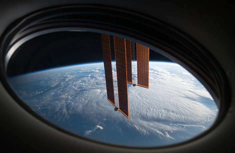 May 20, 2021. In this view from a window aboard the SpaceX Crew Dragon Endeavour, a pair of the International Space Station's main solar arrays drape across the Earth's horizon as the orbital lab soared 271 miles above the south Atlantic in between Argentina and South Africa.