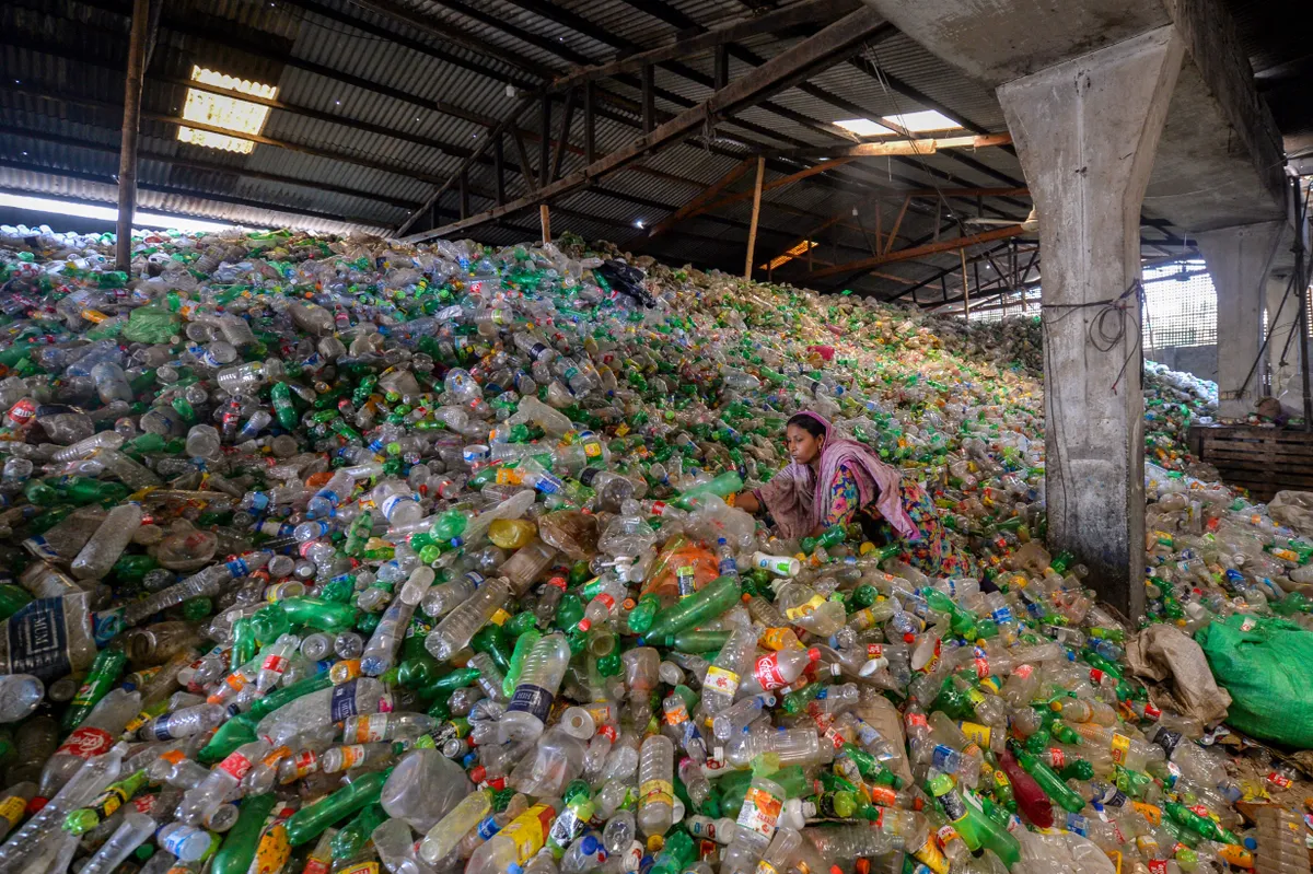 A worker sorts used plastic bottles in a recycling factory in Dhaka on May 5, 2021. (Photo by Munir UZ ZAMAN / AFP) (Photo by MUNIR UZ ZAMAN/AFP via Getty Images)
