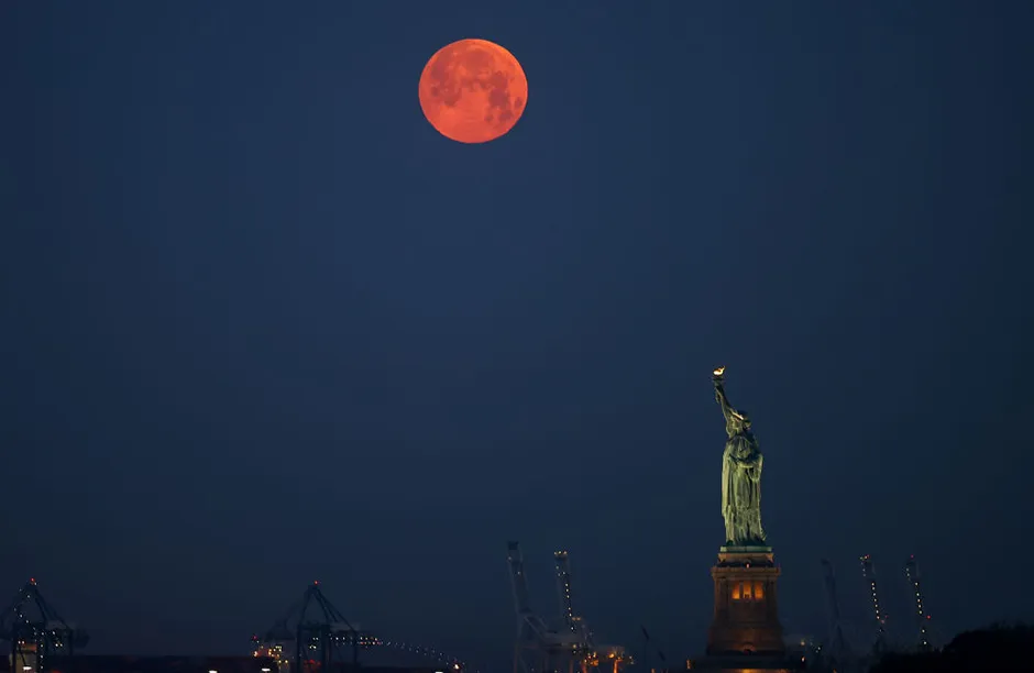'Full Moon' sets behind the Statue of Liberty in New York City, United States on May 26, 2021. (Photo by Tayfun Coskun/Anadolu Agency via Getty Images)