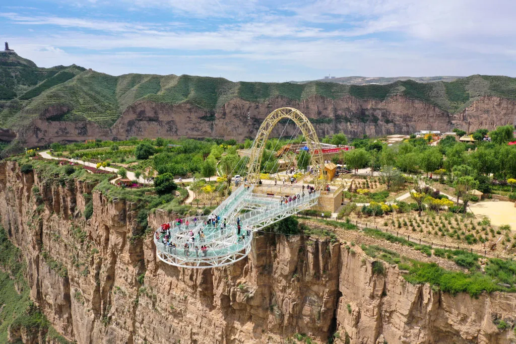 ORDOS, CHINA - JUNE 20, 2021 - Tourists go sightseeing on the suspended viewing platform of the Zhunger Yellow River Grand Canyon scenic area in Ordos, Inner Mongolia, China, June 20, 2021. (Photo credit should read Costfoto/Barcroft Media via Getty Images)
