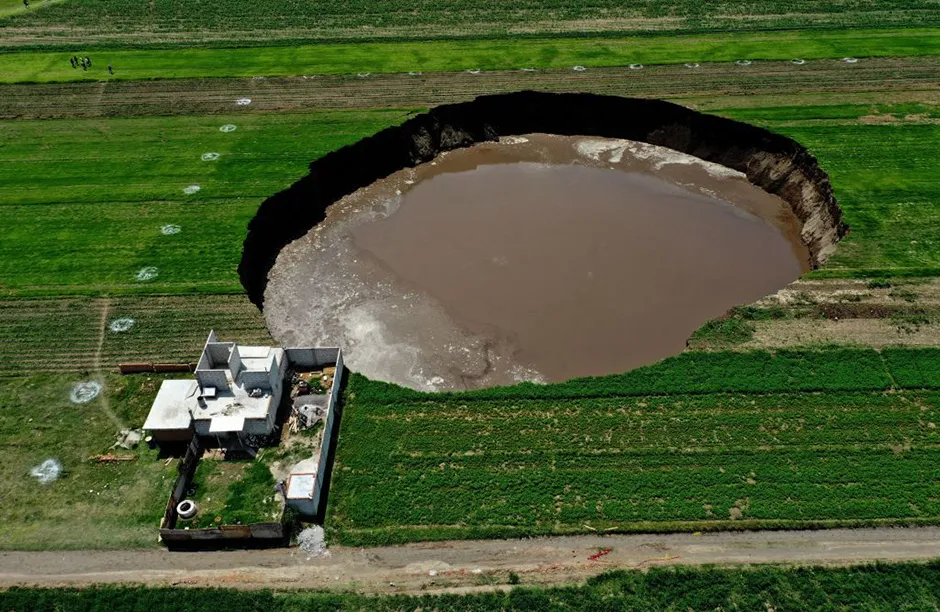 An aerial view of a sinkhole that was found by farmers in a field of crops in Santa Maria Zacatepec, state of Puebla, Mexico on June 01, 2021. (Photo by JOSE CASTAÑARES / AFP) (Photo by JOSE CASTANARES/AFP via Getty Images)