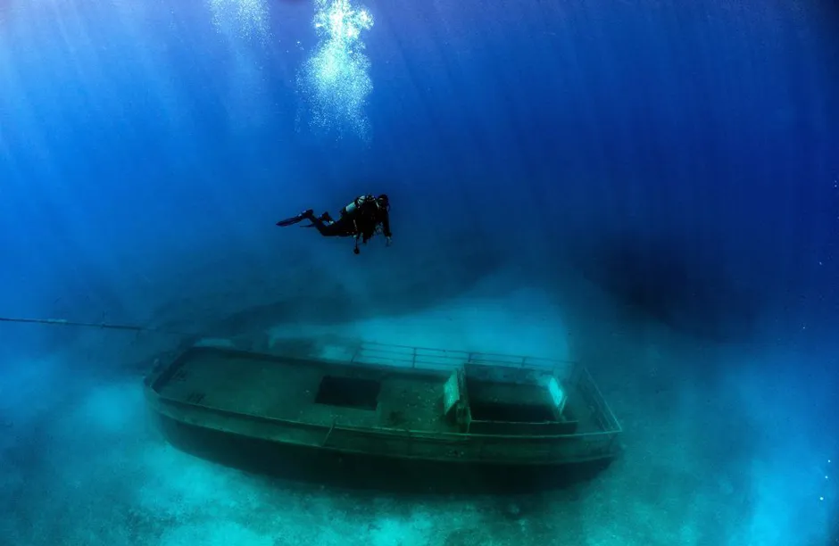 Divers taking part in a project to document shipwrecks in Cyprus with 360 degree images to promote the Mediterranean island as a dive destination for tourists, take photos of the Lef1 shipwreck off the coast of Larnaca on June 8, 2021. - LEF1, a 15 metre long vessel, was sunk on 10th December 2019 to a depth of around 15 metres and is one of several vessels sunk in the islands waters to create artificial reefs to promote marine life in the area. (Photo by Emily IRVING-SWIFT / AFP) (Photo by EMILY IRVING-SWIFT/AFP via Getty Images)