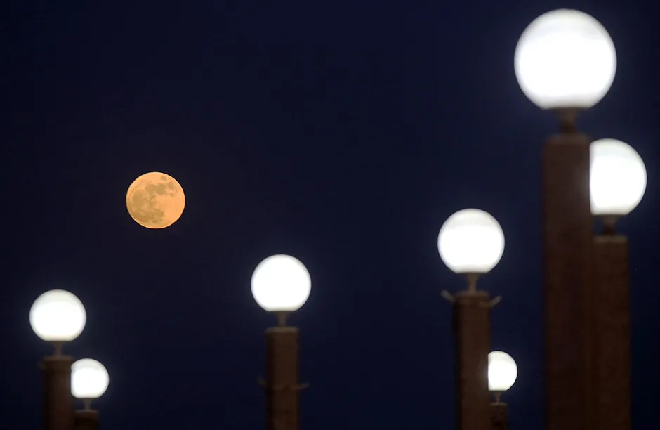 The full Strawberry moon, the last super moon of the year, rises above Kuwait City, on June 24, 2021. (Photo by YASSER AL-ZAYYAT / AFP) (Photo by YASSER AL-ZAYYAT/AFP via Getty Images)